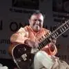 Sitar player Pt. Ashim Chowdhury performing during a live Indian classical music concert.