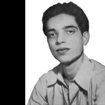 Black-and-white portrait of a young man with neatly styled hair, looking directly at the camera with a calm and slightly serious expression. He is wearing a collared shirt, and the image has a clean, studio-style background with a vintage appearance.