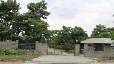 Entrance view of the Centre for Cultural Resources and Training (CCRT) campus featuring a gated pathway, stone boundary walls, and lush green surroundings.