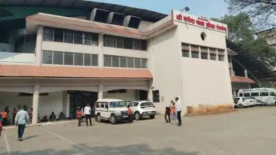 Exterior view of Ganesh Kala Krida Manch featuring a large indoor arena building with parked vehicles and visitors gathered outside during daytime.
