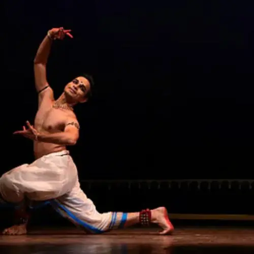 Adithya P.V., Indian classical dancer, performing in a Bharatanatyam-inspired pose during a stage production.