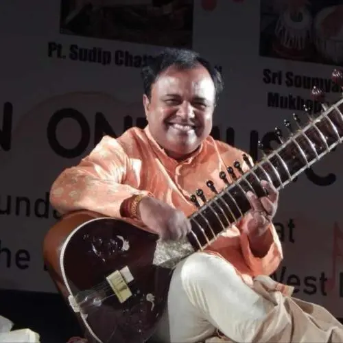 Sitar player Pt. Ashim Chowdhury performing during a live Indian classical music concert.