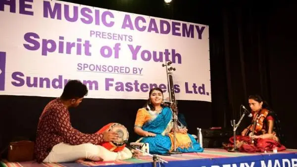 Young Carnatic musicians performing live on stage during The Music Academy’s “Spirit of Youth” festival, featuring vocal, violin, and percussion accompaniment.