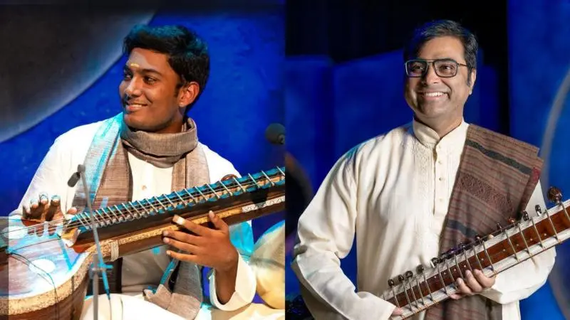 Purbayan Chatterjee and Ramana Balachandhran smiling with their instruments during a Darbar concert performance.