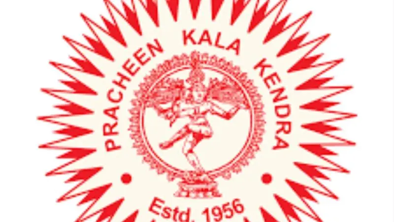 Red circular logo of Pracheen Kala Kendra featuring a classical Nataraja figure in the center, surrounded by decorative rays and the text “Estd. 1956.”