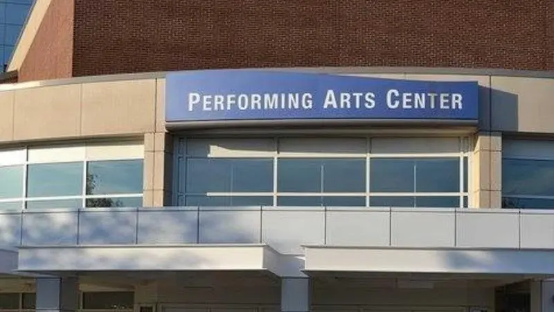 Exterior entrance of Harper College Performing Arts Center with signage above glass doors on a brick building façade.