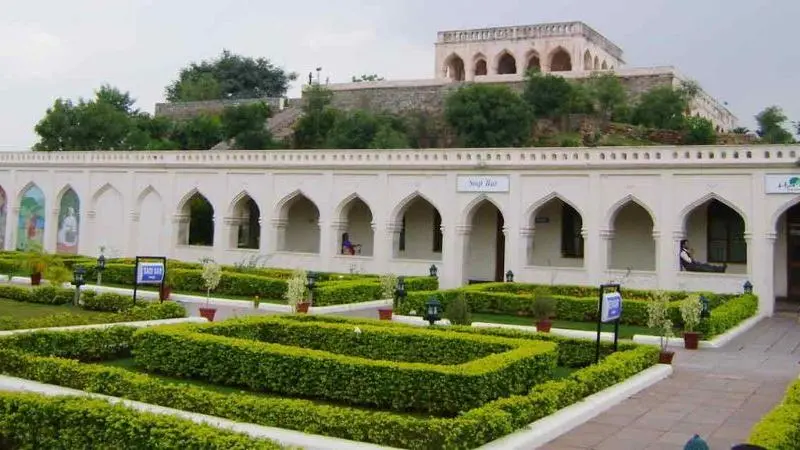 View of Taramati Baradari featuring Mughal-style arched corridors, landscaped gardens and the historic pavilion structure situated on an elevated hill in Hyderabad.