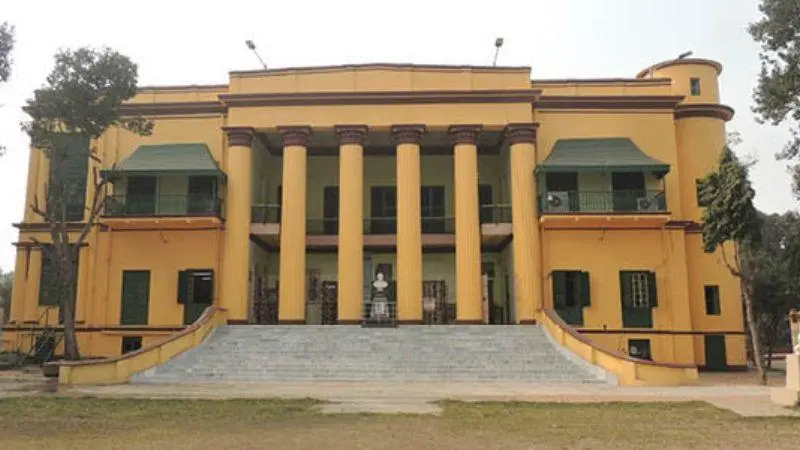 Front view of the historic Uttarpara Jaykrishna Public Library building featuring classical colonial-style architecture with tall pillars, wide staircases and a symmetrical yellow facade.